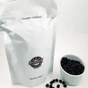 A bag of coffee beans next to a cup.