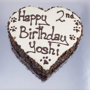 A heart shaped cake with the words " happy 2 nd birthday yoshi ".